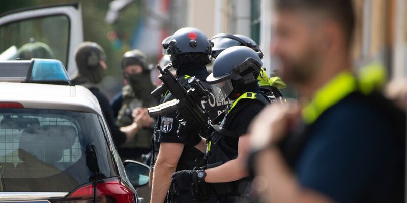 Bewaffnete Polizeikräfte unweit des Einsatzortes in Berlin-Spandau. - Foto: Paul Zinken/dpa