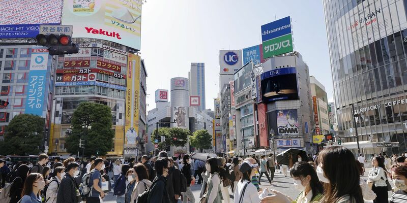 Menschen gehen in Japans Hauptstadt Tokio über eine Kreuzung. - Foto: kyodo/dpa