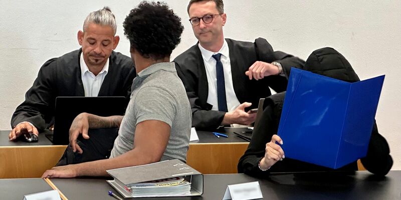 Eine ehemalige Justizvollzugsbeamtin (vorn r) und ein Häftling der Justizvollzugsanstalt Kaisheim (vorn l) sitzen auf der Anklagebank im Strafjustizzentrum Augsburg, im Hintergrund die Strafverteidiger. - Foto: Ulf Vogler/dpa