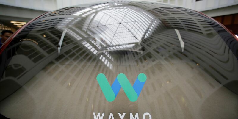 Das Logo der Google-Schwesterfirma Waymo ist während eines Google-Events auf der Scheibe eines fahrerlosen Waymo-Autos zu sehen. - Foto: Eric Risberg/AP/dpa