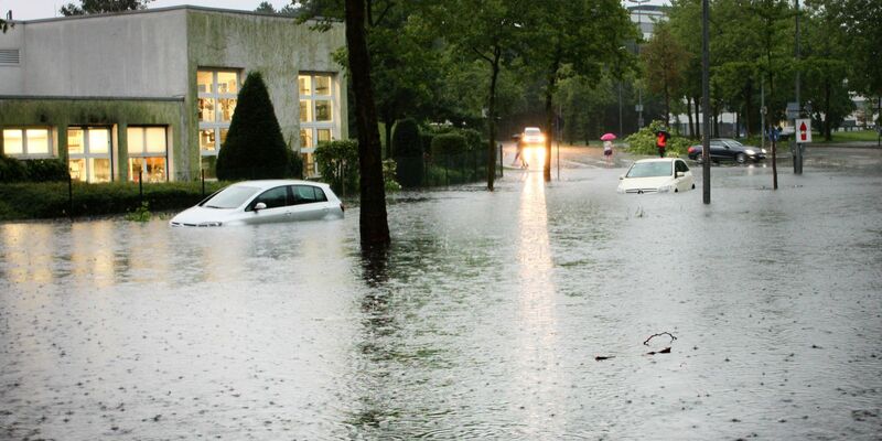 Autos auf einer überfluteten Straße in Münster. Der Grund: Heftige Regenfälle. - Foto: Philipp Seibt/dpa