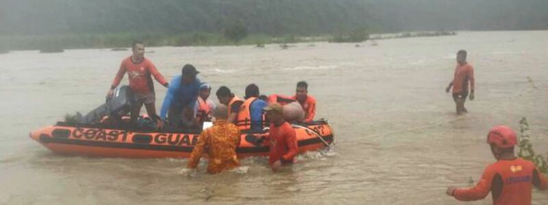 Steinbrucharbeiter werden in Naguilian (Philippinen) mit einem Schlauchboot evakuiert. - Foto: PHILIPPINE COAST GUARD/AP/dpa