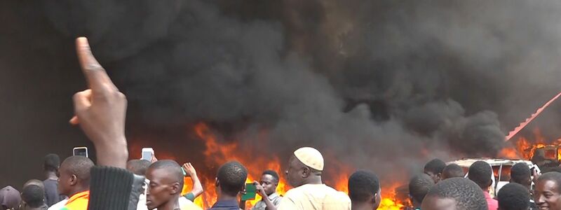 Anhänger meuternder Soldaten sind auf den Straßen von Nigers Hauptstadt Niamey unterwegs, das Hauptquartier der Regierungspartei steht in Flammen. Das Militär hat erklärt, die Forderung der Putschisten nach einem Ende der Amtszeit von Präsident Bazoum zu unterstützen. - Foto: Fatahoulaye Hassane Midou/AP/dpa