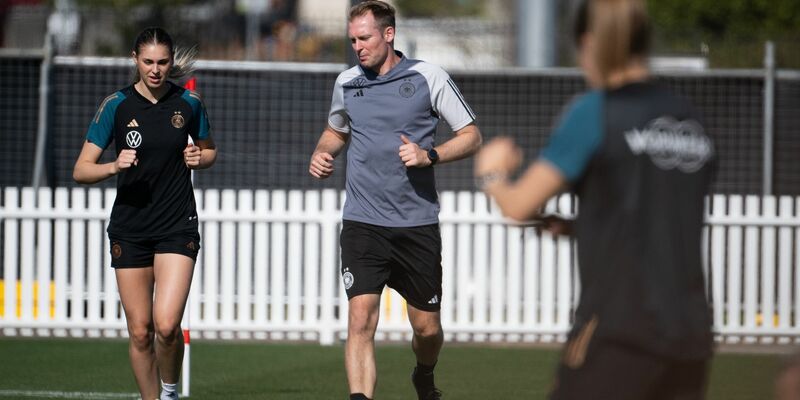 Jule Brand (l) trainiert am Rand des Trainingsplatzes. - Foto: Sebastian Christoph Gollnow/dpa
