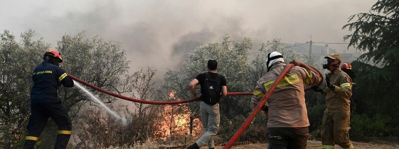 Feuerwehrleute und Freiwillige versuchen, einen Brand bei Nea Anchialos zu löschen. - Foto: Tatiana Bolari/Eurokinissi/AP/dpa