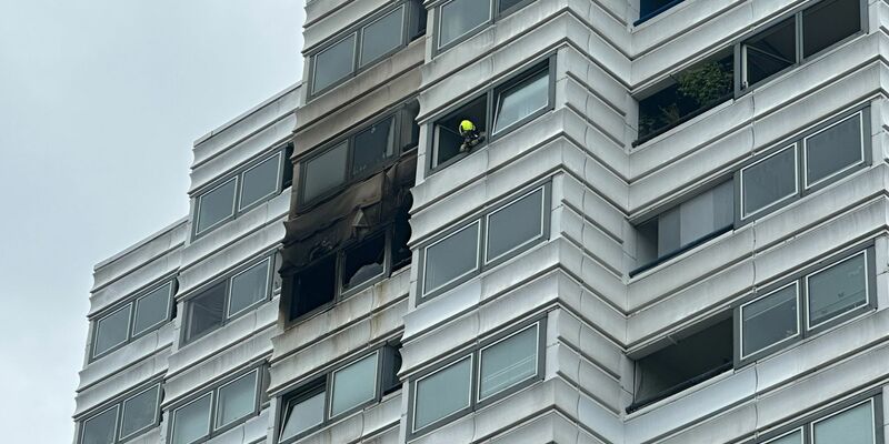 Einsatzkräfte vor dem Hochhaus in Berlin, in dem ein Feuer im zehnten Stock ausgebrochen war. - Foto: Annette Riedl/dpa