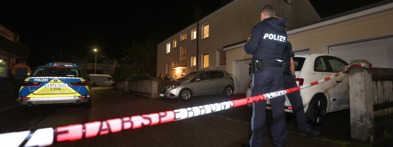 Polizisten am Tatort vor dem Haus in Langweid, in dem drei Menschen erschossen wurden. - Foto: Karl-Josef Hildenbrand/dpa