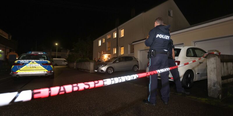 Polizisten stehen vor einem Haus, in dem drei Menschen erschossen wurden. - Foto: Karl-Josef Hildenbrand/dpa