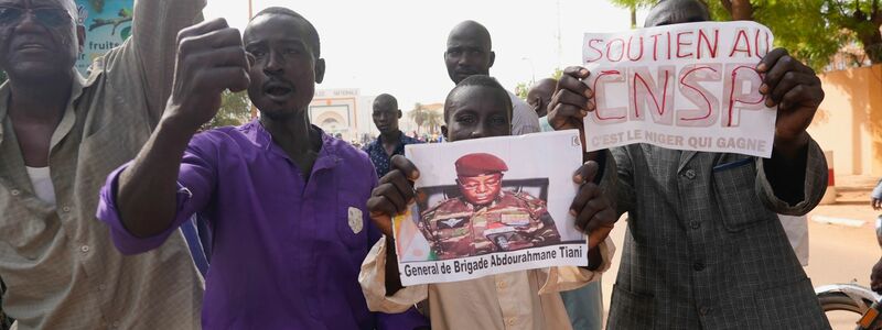 Menschen mit Plakaten des Putschisten General Omar Tchiani  
in Niamey. - Foto: Sam Mednick/AP/dpa