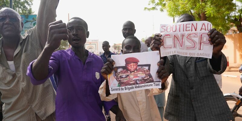 Menschen mit Plakaten des Putschisten General Omar Tchiani  
in Niamey. - Foto: Sam Mednick/AP/dpa