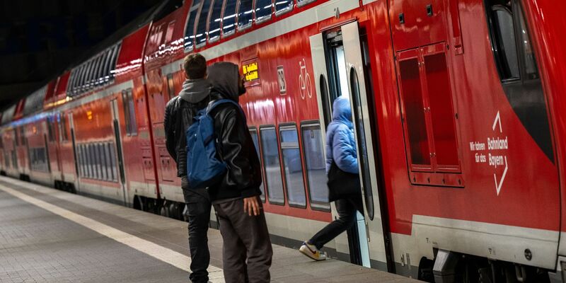 Reisende im Hauptbahnhof München vor einer Regionalbahn. Die Mitglieder der Eisenbahn- und Verkehrsgewerkschaft (EVG) stimmen im August darüber ab, ob es zu einem Tarifabschluss mit der Deutschen Bahn kommt oder zu unbefristeten Streiks. - Foto: Peter Kneffel/dpa