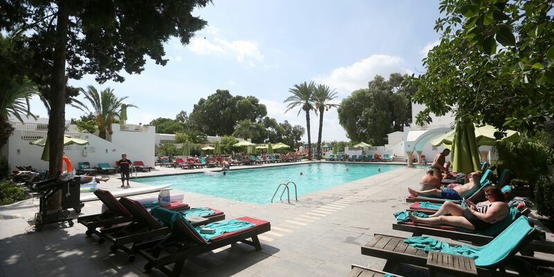Urlauber entspannen am Swimmingpool eines Hotels in Tunesien. - Foto: Mohamed Krit/BELGA/dpa
