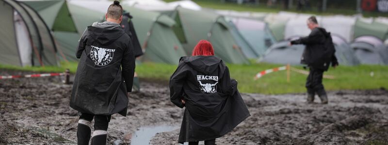 Metal-Fans auf dem schlammigen Festivalgelände in Wacken. - Foto: Christian Charisius/dpa