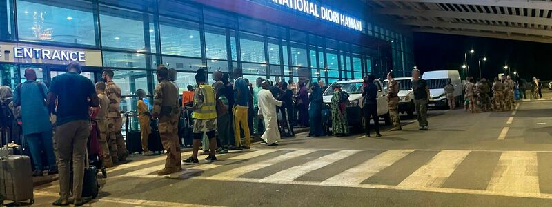 Menschen sind vor dem dem internationalen Flughafen von Niamey zu sehen. Knapp eine Woche nach dem Militärputsch im Niger hat Frankreich mit der Evakuierung seiner Staatsbürger aus dem westafrikanischen Land begonnen. - Foto: Generalstab der französischen Armee/dpa