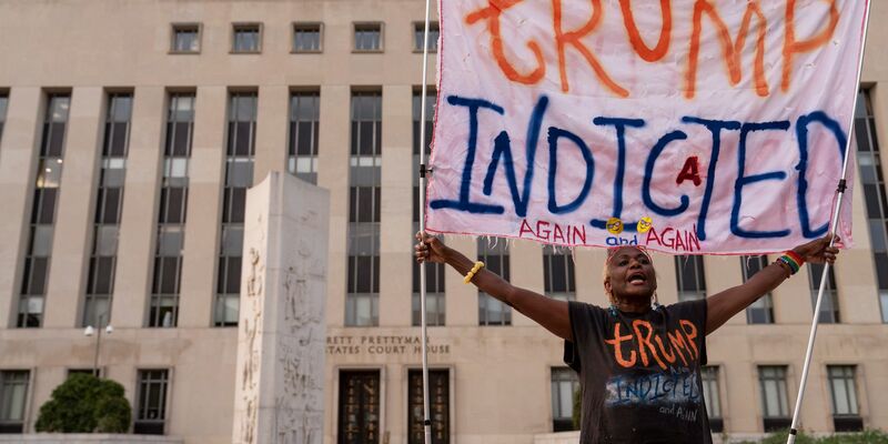 «Trump angeklagt - wieder und wieder» steht auf dem Transparent von Nadine Seiler. Sie steht vor dem Bundesgericht, wo der einstige US-Präsident heute erscheinen soll. Noch ist unklar, ob er persönlich anreisen wird. - Foto: Jose Luis Magana/AP