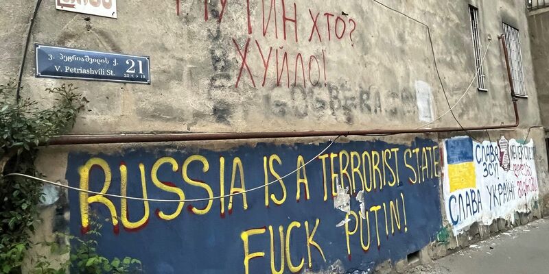 An einer Hauswand in einem Viertel der Hauptstadt Tiflis stehen auf Englisch und auf Ukrainisch antirussische Parolen, die den Krieg von Kremlchef Wladimir Putin gegen die Ukraine verurteilen. - Foto: Ulf Mauder/dpa