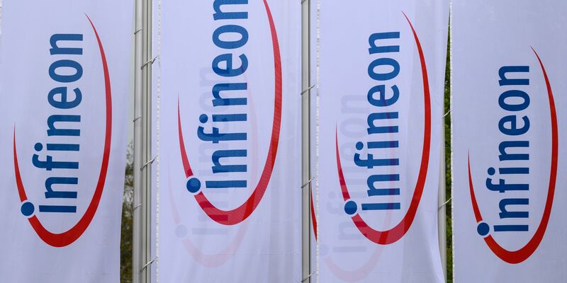 Fahnen mit dem Logo von Infineon wehen vor dem Werk des Chipherstllers in Dresden im Wind. - Foto: Robert Michael/dpa