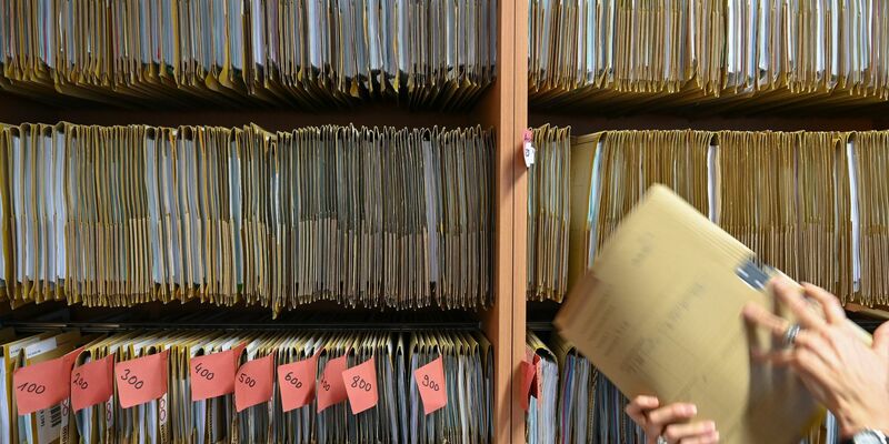 Eine Mitarbeiterin des Amtsgerichts Frankfurt greift an einem Regal nach einer Gerichtsakte. Der digitale Wandel in der hessischen Justiz ist mit der Einführung der E-Akte ein weiteres Stück vorangekommen. - Foto: Arne Dedert/dpa