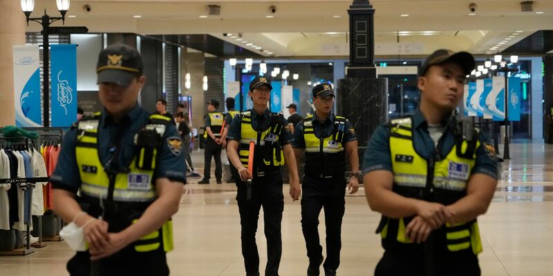 Polizisten patrouillieren am Tatort in der Nähe einer U-Bahn-Station in Seongnam. - Foto: Ahn Young-joon/AP/dpa