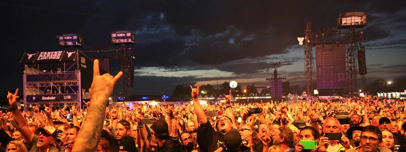 Metal-Fans feiern während eines Konzerts auf dem Festivalgelände. - Foto: Christian Charisius/dpa