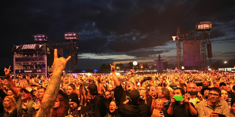 Metal-Fans feiern während eines Konzerts auf dem Festivalgelände. - Foto: Christian Charisius/dpa