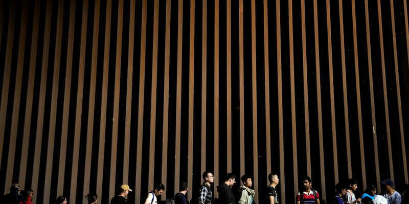 Menschen warten darauf, nach dem Grenzübertritt aus Mexiko Asyl zu beantragen. Die Lage an der südlichen US-Grenze ist seit Jahren angespannt. - Foto: Gregory Bull/AP/dpa
