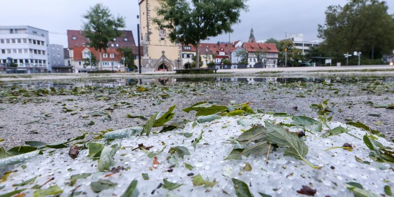 Hagelkörner und vom Sturm abgerissene Blätter liegen in Reutlingen auf dem Boden. - Foto: Thomas Warnack/dpa
