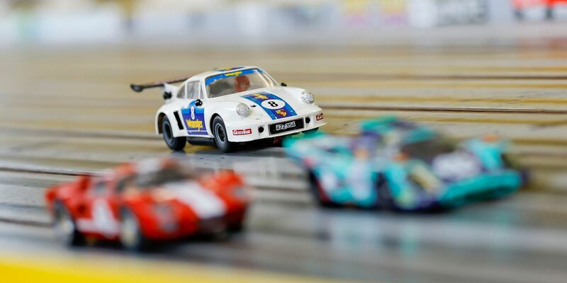 Carrera-Autos fahren auf der Rennstrecke im Rennbahn-Center Franken im bayerischen Heroldsberg. - Foto: Daniel Löb/dpa