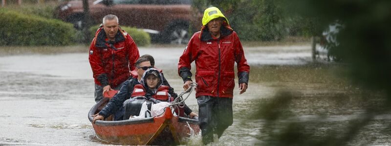 Touristen werden in der Steiermark aus ihren Unterkünften mit Booten auf überfluteten Straßen in Sicherheit gebracht. - Foto: Erwin Scheriau/APA/dpa