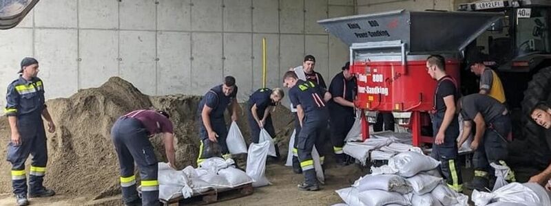 Mitarbeiter der Feuerwehr befüllen in Deutschlandsberg (Steiermark) Sandsäcke im Kampf gegen die Überflutungen in der Gegend. - Foto: -/BFVMZ/APA/dpa