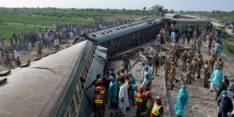 Rettungskräfte und Soldaten versuchen nach dem Unglück in der südpakistanischen Provinz Sindh, Menschen aus dem entgleisten Zug zu befreien. - Foto: Pervez Masih/AP/dpa