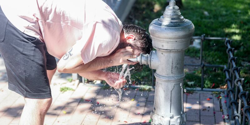 Eine Mann kühlt sich an einem Trinkbrunnen in Madrid ab. - Foto: Ricardo Rubio/EUROPA PRESS/dpa