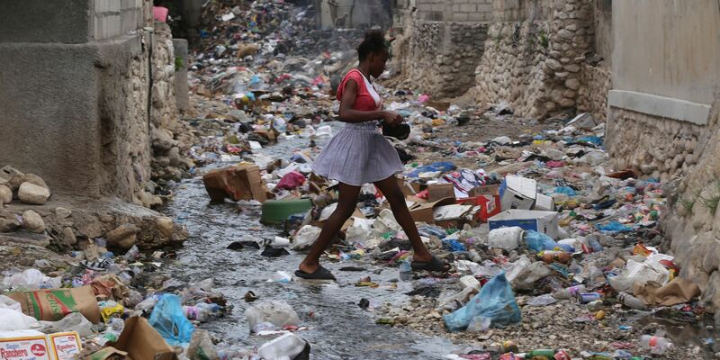 Ein Mädchen geht durch eine mit Müll gefüllte Häuserschlucht in Port-au-Prince. Bewaffnete Gruppen entführen dort zunehmend Kinder und Frauen - in den meisten Fällen zu finanziellen oder taktischen Zwecken. - Foto: Odelyn Joseph/AP