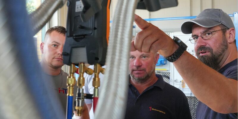 Meisterschüler Martin Scholz (r) unterhält sich mit Kollegen im Wärmepumpen-Labor auf dem Bildungs- und Innovationscampus der Handwerkskammer Potsdam (BIH). - Foto: Soeren Stache/dpa