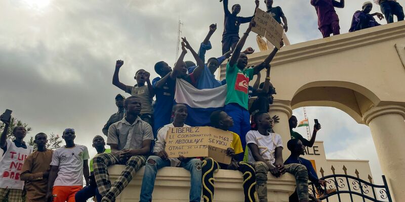 Anhänger der regierenden Junta im Niger jubeln auf der Straße. Am 26. Juli hatten Offiziere der Präsidialgarde in dem westafrikanischen Land den demokratisch gewählten Präsidenten Mohamed Bazoum entmachtet. - Foto: Sam Mednick/AP/dpa/Archiv