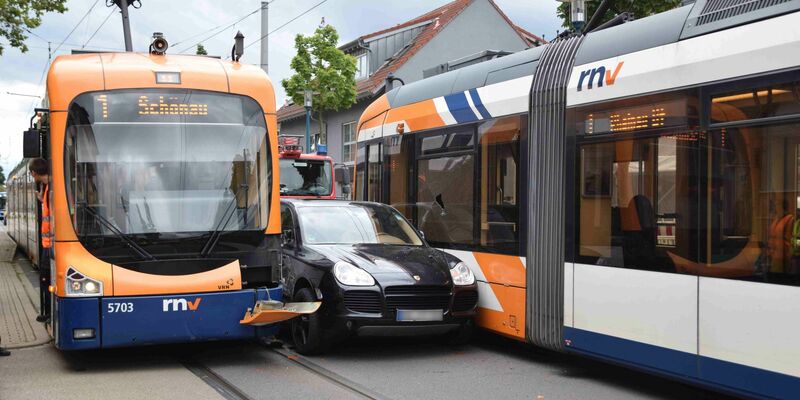 Ein Porsche ist nach einem leichtsinnigen Überholmanöver zwischen zwei Straßenbahnen eingeklemmt. - Foto: Priebe/pr-video/dpa