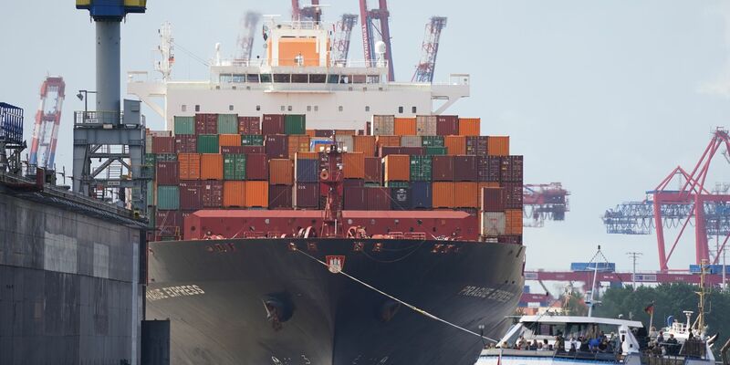 Das Containerschiff «Prague Express» der Reederei Hapag-Lloyd wird von Schleppern an einen Containerterminal im Hafen gezogen. - Foto: Marcus Brandt/dpa