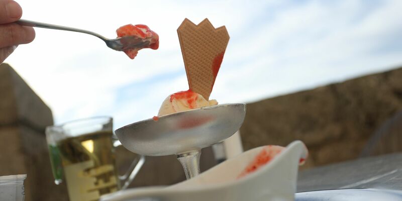 Eine Frau isst ein Eis. Auch bei reduzierter Mehwertsteuer verzichten viele Kundinnen und Kunden vor dem Hintergrund der aktuellen Konjunkturflaute auf einen Café-Besuch. - Foto: Karl-Josef Hildenbrand/dpa