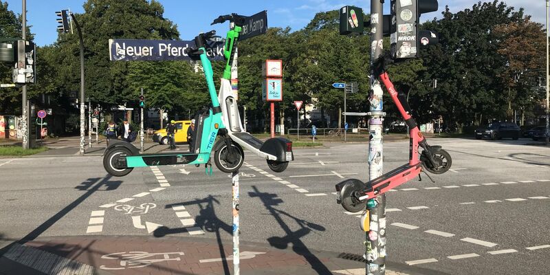 Drei E-Scooter hängen an Masten im Hamburger Stadtteil St. Pauli. - Foto: Stefan Flomm/dpa
