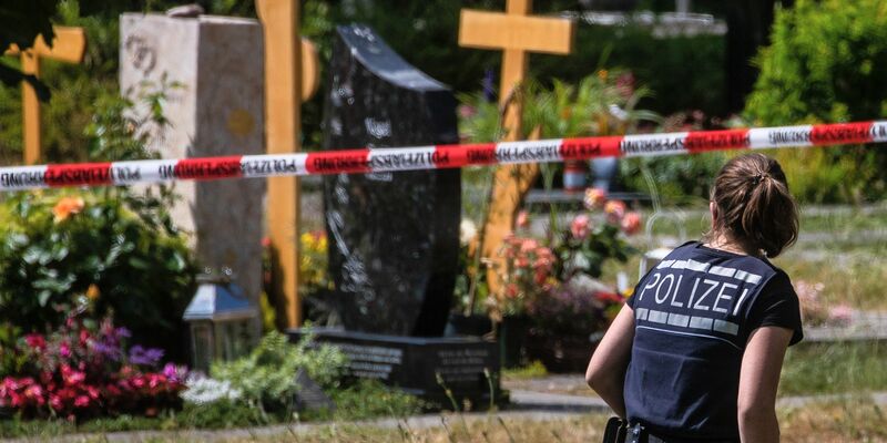 Eine Polizistin geht über den abgesperrten Teil eines Friedhofs in Altbach, wo im Juni eine Handgranate auf eine Trauergemeinde geworfen wurde. - Foto: Christoph Schmidt/dpa