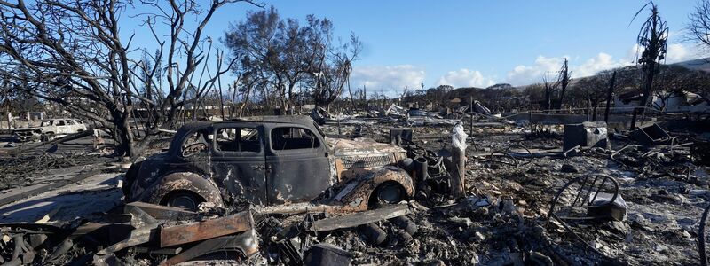 Ein ausgebranntes Auto steht mitten in einem völlig zerstörten Gebiet der Kleinstadt Lahaina. - Foto: Rick Bowmer/AP