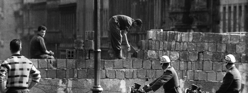 Arbeiter erhöhen die Sektorensperre an der Bernauer Straße in Berlin. Mit dem Bau am 13. August wurde vor 62 Jahren begonnen. - Foto: dpa