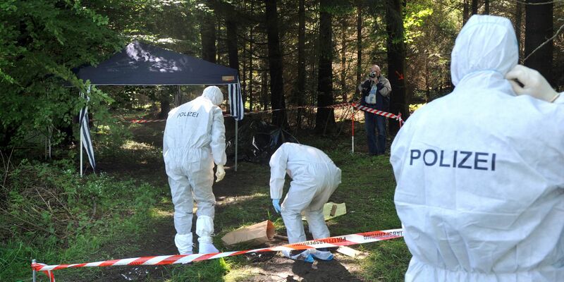 Kriminalbeamte untersuchen im Juni 2010 bei Heidenheim-Nietheim den Waldboden. - Foto: Stefan Puchner/dpa