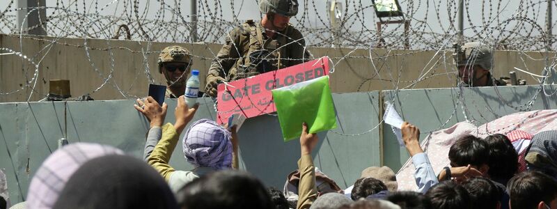 Ein US-Soldat hält wenige Tage nach der Machtübernahme der Taliban 2021 ein Schild, mit der Aufschrift «Gate closed» auf dem internationalen Flughafen von Kabul. - Foto: Wali Sabawoon/AP/dpa