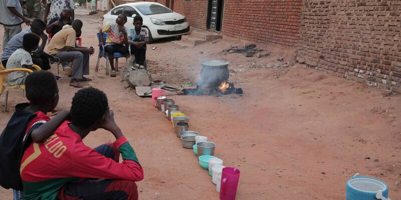 Menschen bereiten in einem Viertel von Khartum Essen zu. - Foto: -/AP/dpa