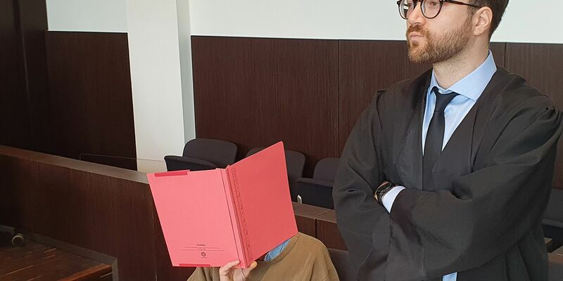 Der Angeklagte (l) sitzt neben seinem Verteidiger Maximilian Klefenz im Verhandlungssaal des Düsseldorfer Landgerichts und verdeckt sein Gesicht. - Foto: Martin Höke/dpa