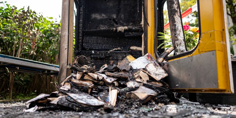 Verbrannte Bücher liegen in der ausgebrannten Bücherbox in der Nähe des Mahnmals «Gleis 17». Dem Täter ist die Polizei möglicherweise auf der Spur. - Foto: Fabian Sommer/dpa