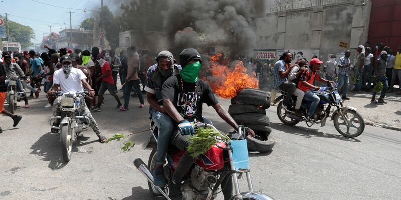 Demonstranten fahren mit ihren Motorrädern an einer brennenden Barrikade vorbei, während sie gegen die Unsicherheit in Port-au-Prince protestieren. - Foto: Odelyn Joseph/AP