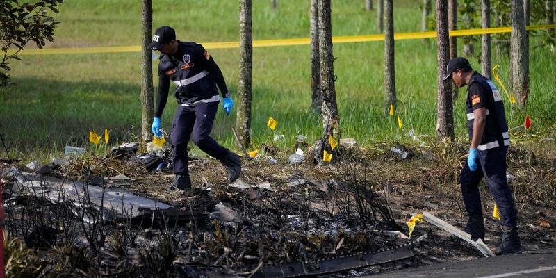 Polizisten ermittelt an der Absturzstelle des Kleinflugzeugs in Malaysia. - Foto: Vincent Thian/AP