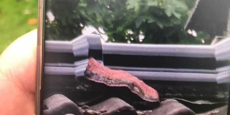 Ein Stück Bauschaum quilt aus einer Dachkante in Neuss. - Foto: Polizei Rhein-Kreis Neuss/dpa